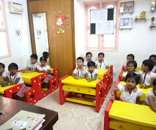 Preschool classroom with children at colourful desks, Mrs Reena's Cocoon Play School